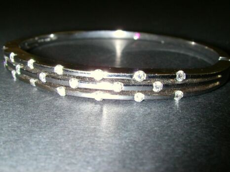 Lot image - White Gold and Diamond Bangle Bracelet  18 kt. white gold, the hinged band set to the top with twenty small round diamonds,...