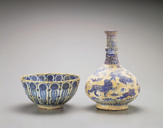 Lot image - PERSIAN BLUE AND WHITE POTTERY BOTTLE VASE AND BOWL  Probably 13th century and circa 17th century  Height 9 1/4 inches (23.5 cm); diame