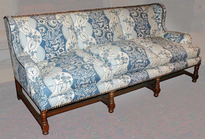 Lot image - Upholstered Walnut Three-Seat Wing Sofa