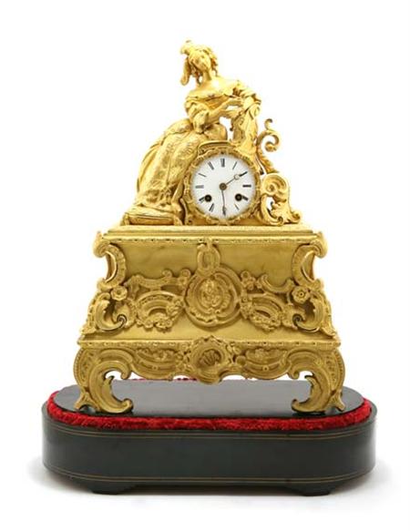 Lot image - Louis Philippe Gilt-Bronze Figural Mantel Clock; Together with a Napoleon III Brass String Inlaid Ebonized Oval Stand