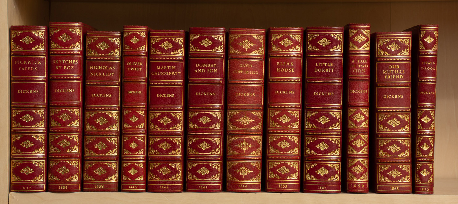 Lot image - DICKENS, CHARLES  Twelve volumes of first and early editions of the major works of Dickens, uniformly bound in scarlet morocco.