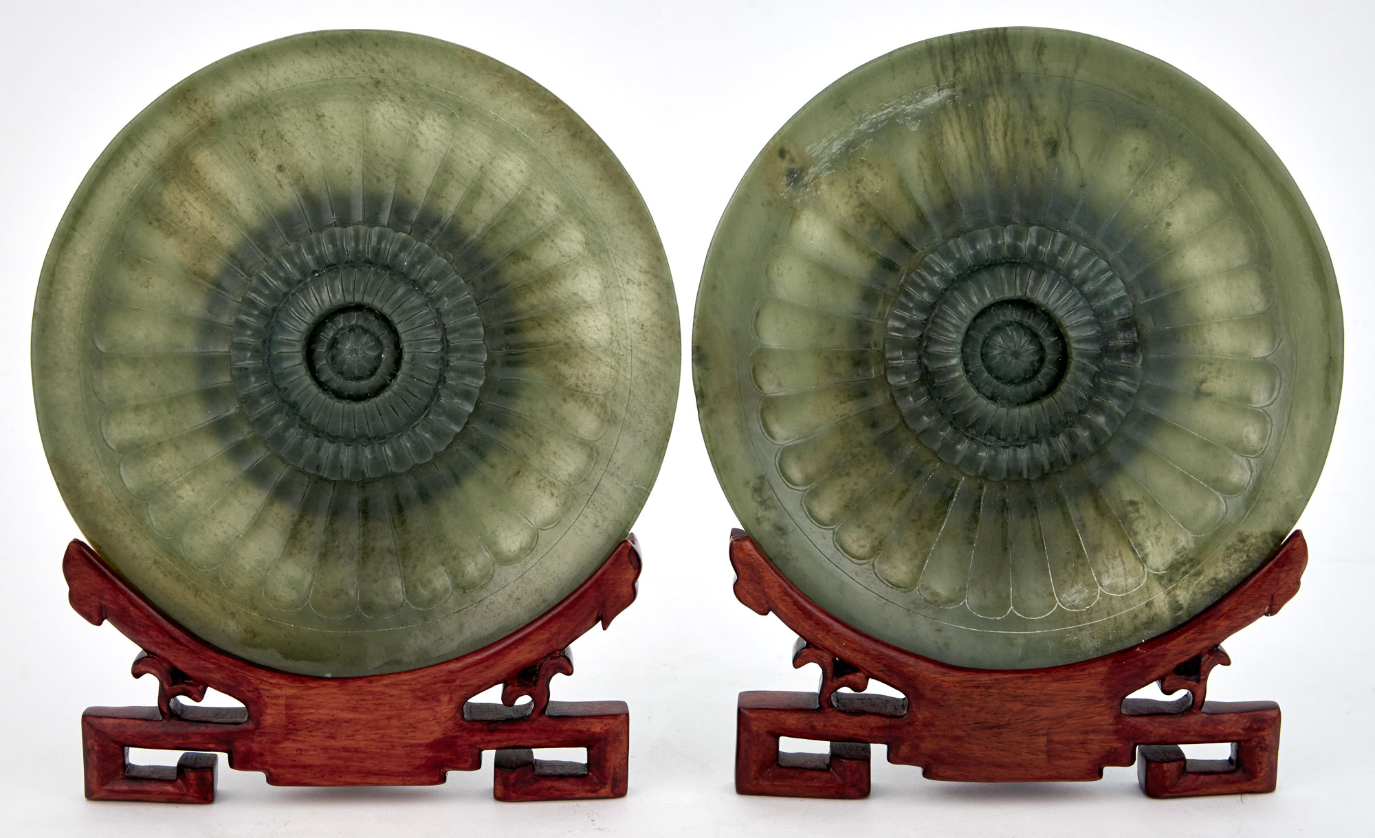 Lot image - Pair of Chinese Carved Green Hardstone Chrysanthemum Flowerhead-Form Plates and Hardwood Stands