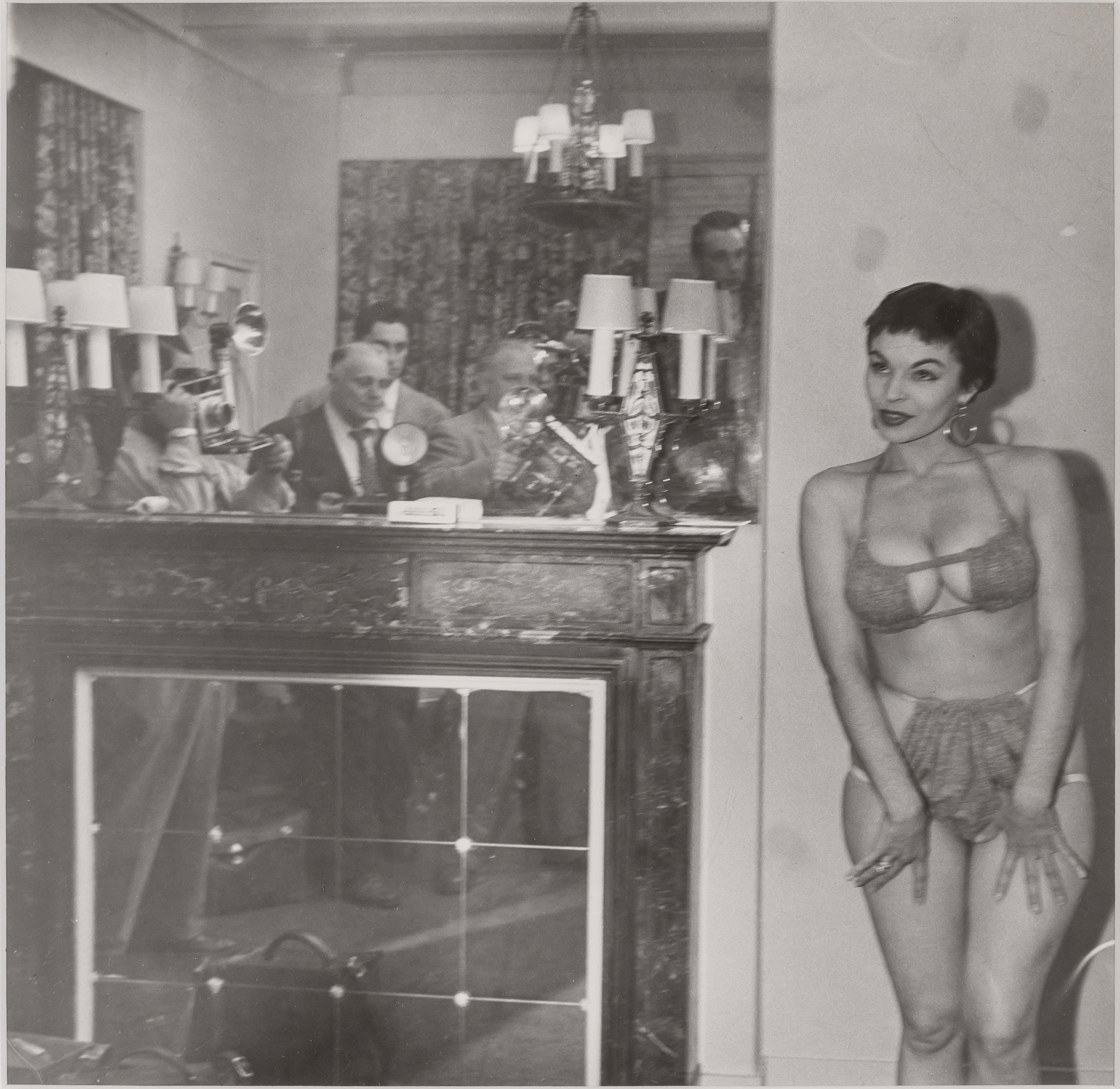 Lot image - WEEGEE [=FELLIG, ARTHUR] (1899-1968)  A stripper posing for the press,