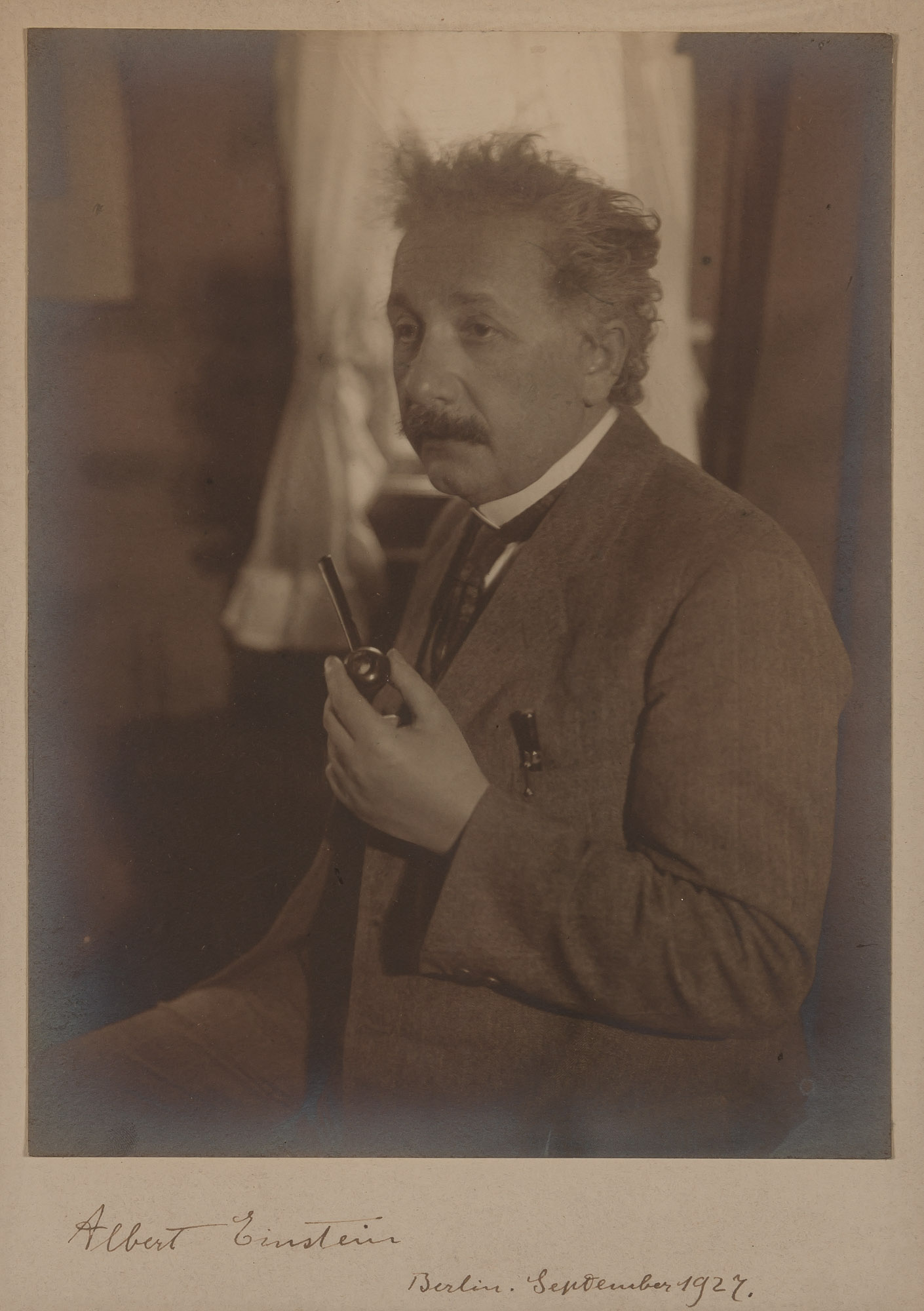 Lot image - EINSTEIN, ALBERT  Photograph signed on the mount in brown ink below the image Albert Einstein/Berlin. September 1927.