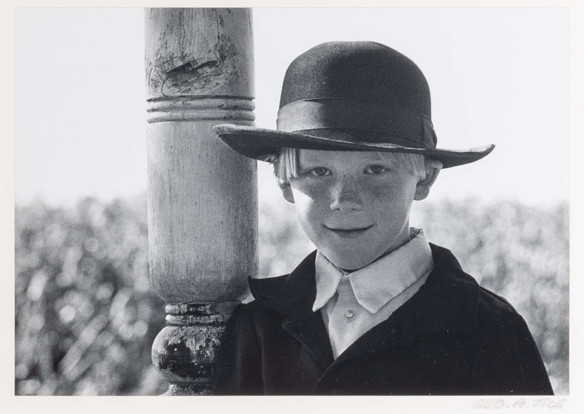 Lot image - TICE, GEORGE A. (b. 1938)  Amish boy leaning on post, Lancaster PA