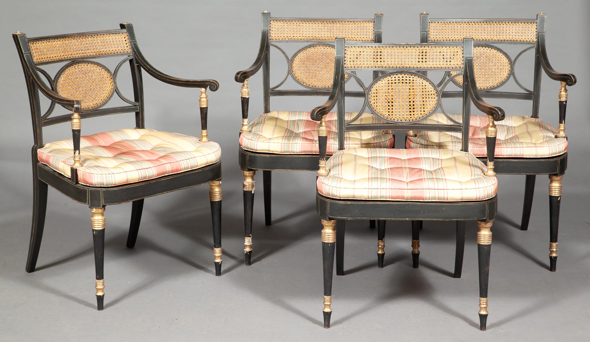 Lot image - Set of Four Regency Black-Painted and Parcel-Gilt Caned Open Armchairs