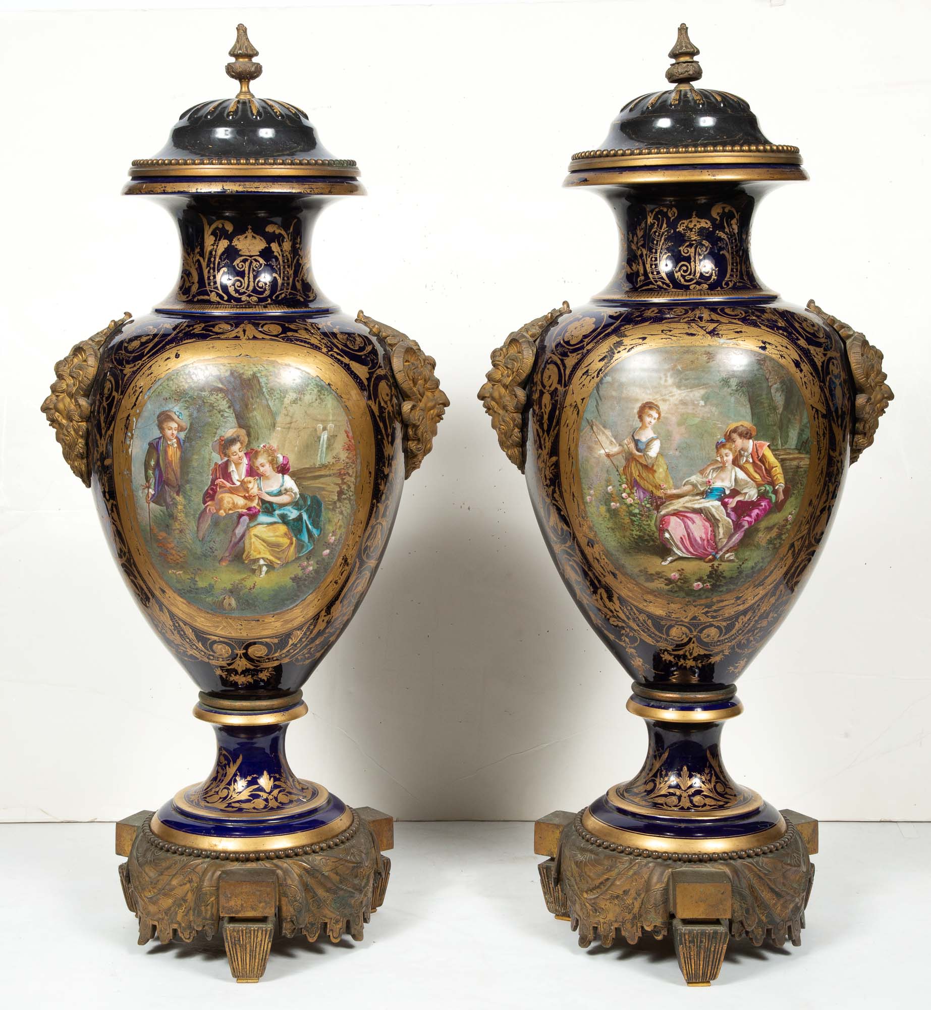 Lot image - Pair of Sèvres Style Gilt-Bronze Mounted Gilt and Hand-Painted Cobalt Ground Porcelain Two-Handled Urns with Covers