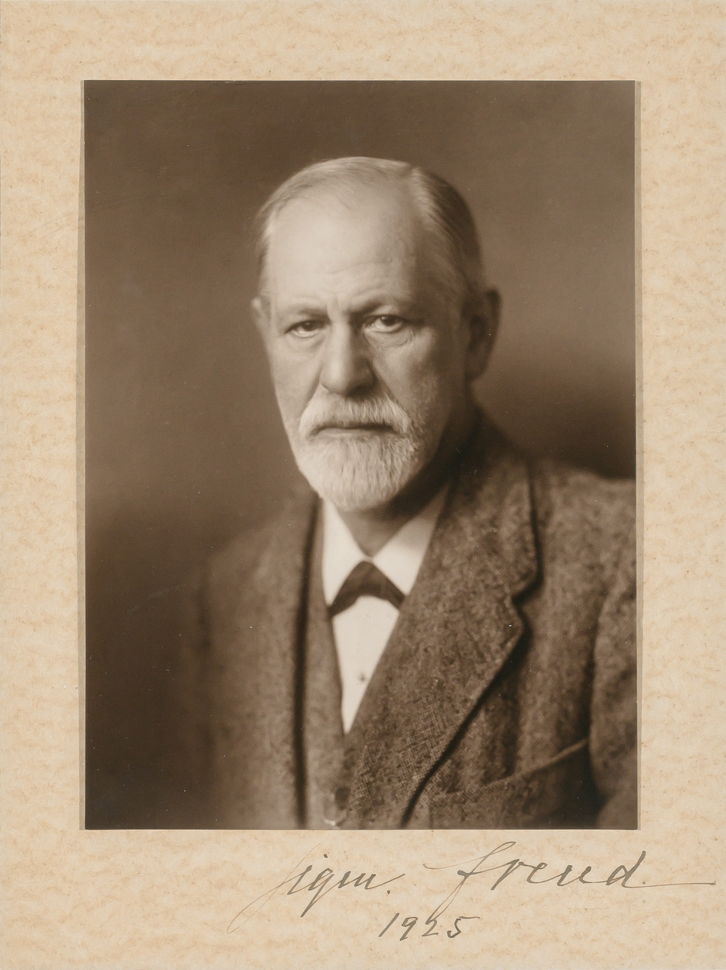 Lot image - [FREUD, SIGMUND]  HALBERSTADT, MAX. Photographic portrait of Sigmund Freud, signed in ink on the mount by the sitter (Sigm. Freud) and dated 1925.  Hamburg: circa